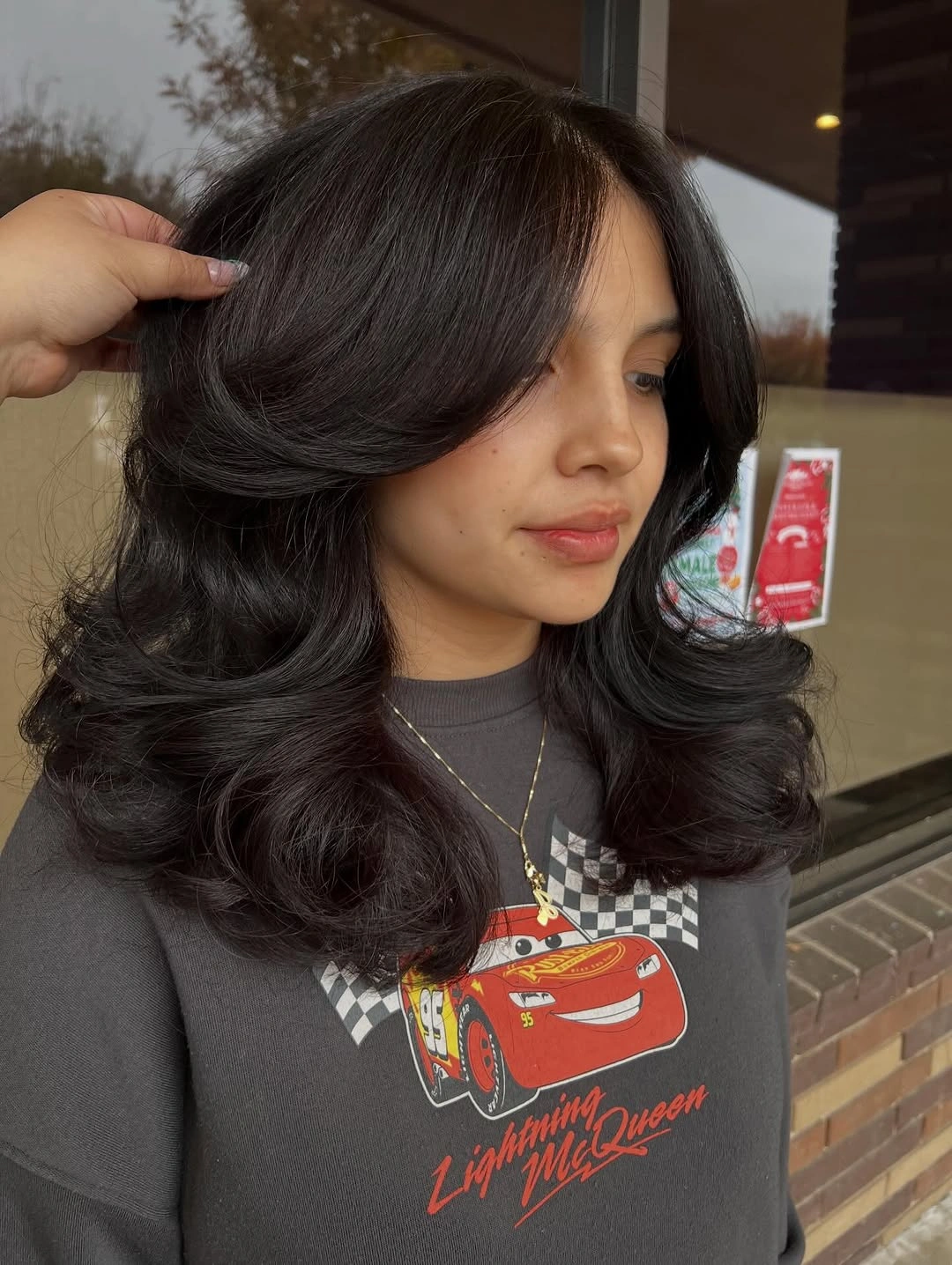 Medium-long dark layered haircut with side-swept front and curved ends