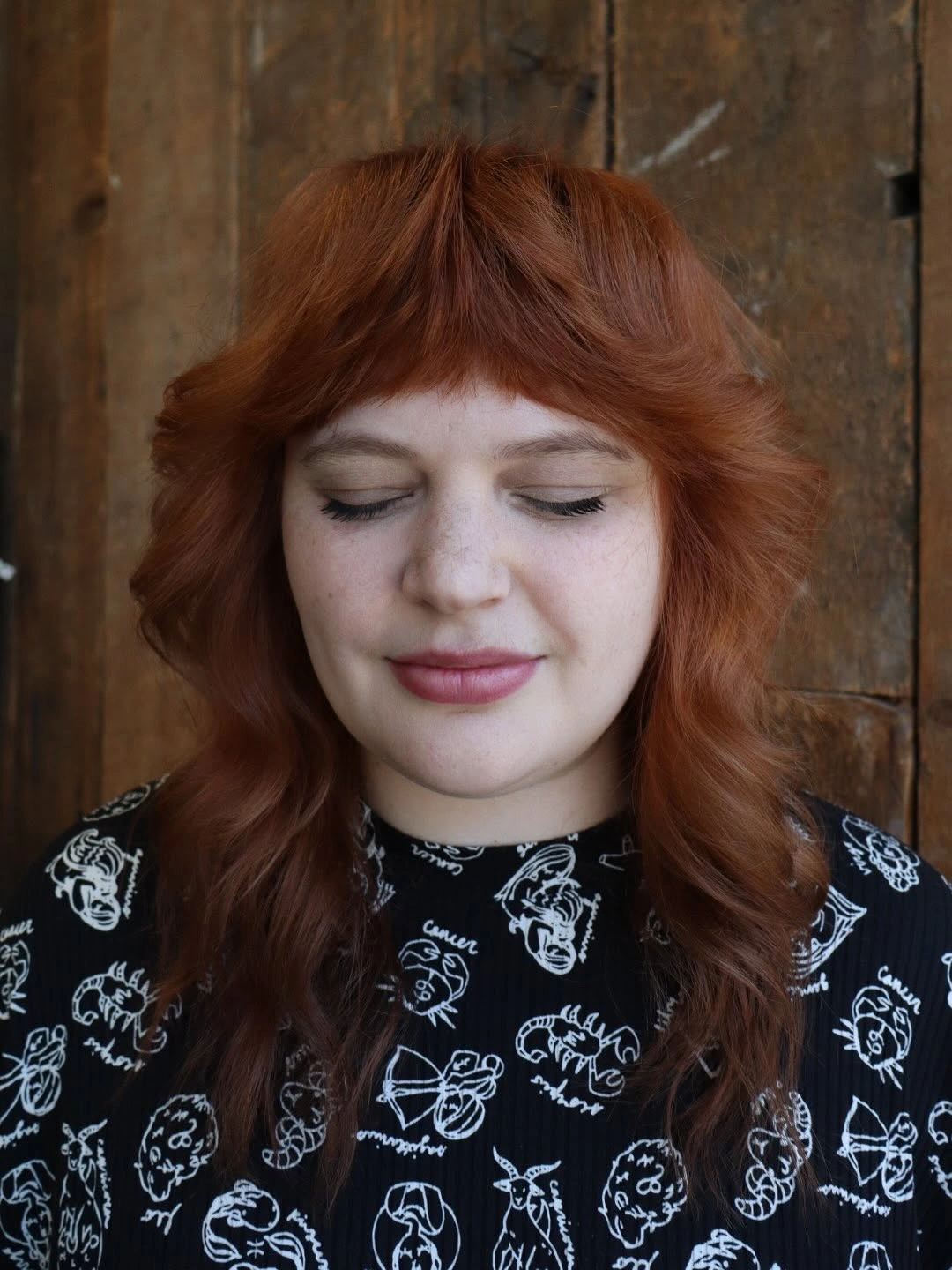 Medium copper wavy shag-like haircut with short bangs