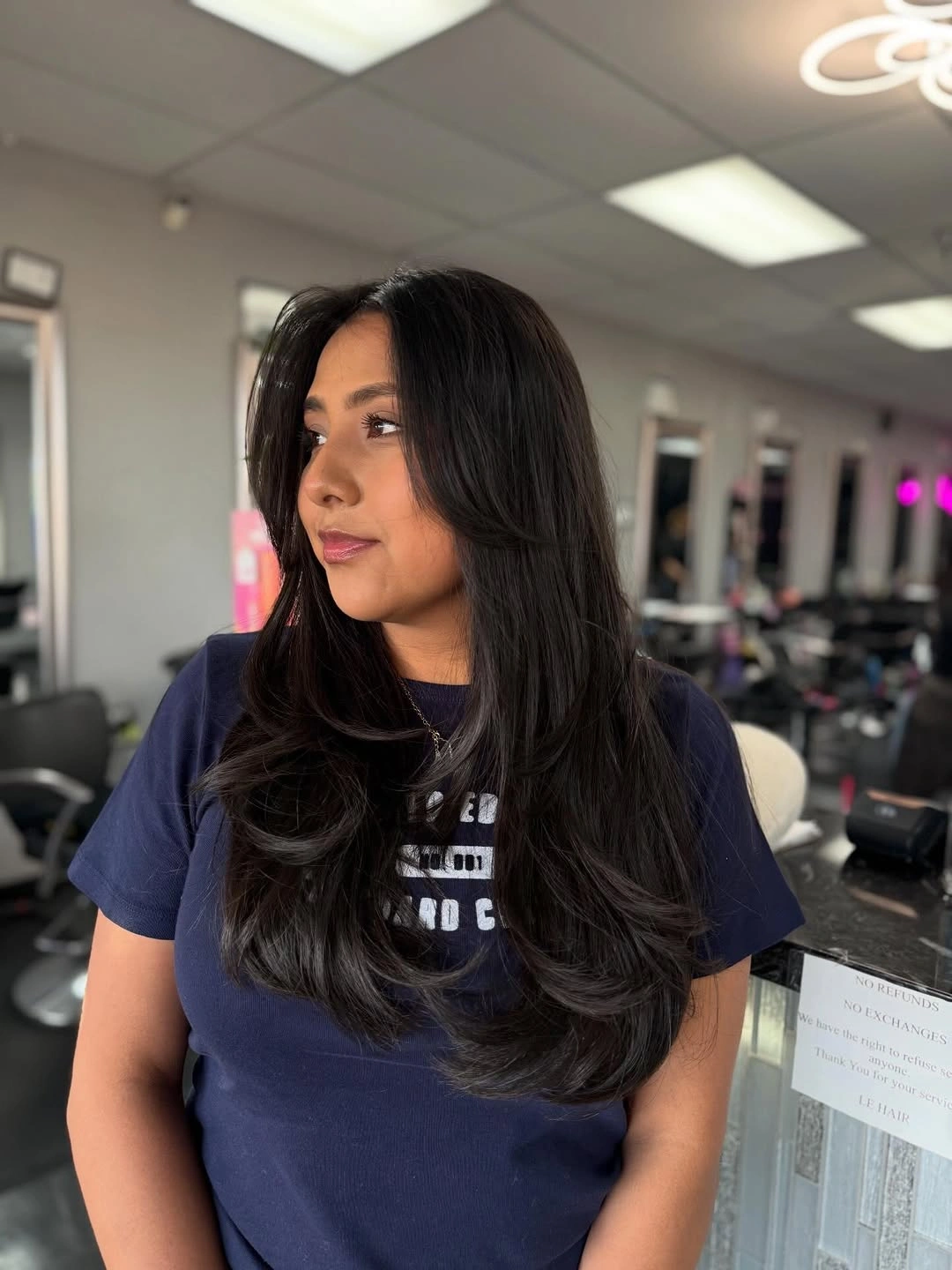 Long dark layered haircut with center part and curved front pieces