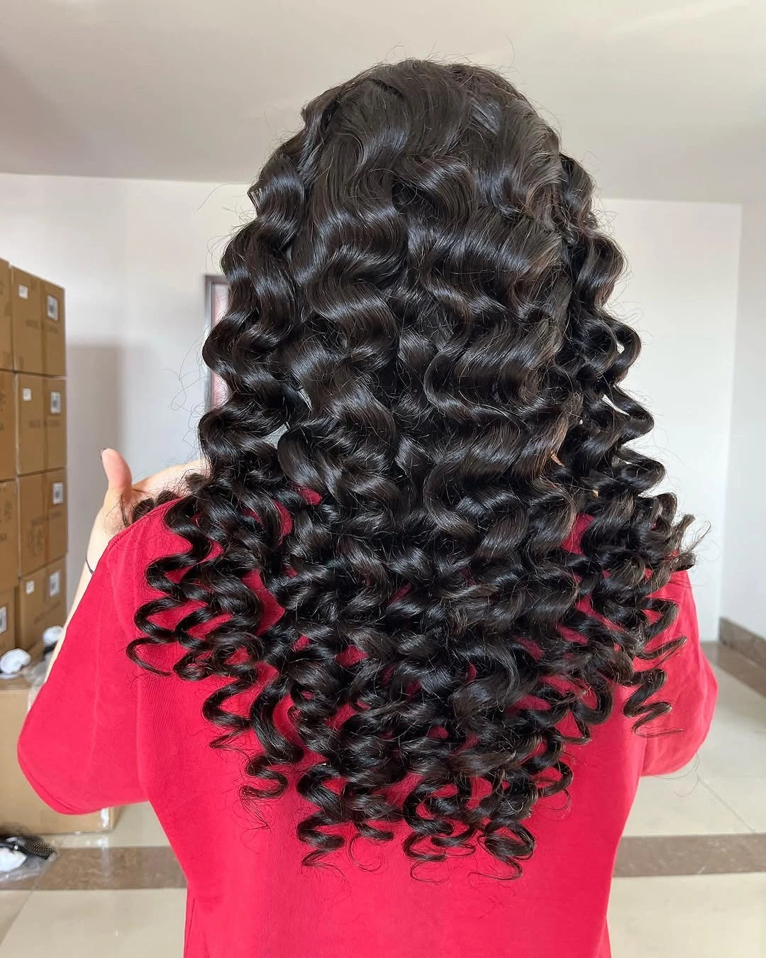 Back view of long black glossy barrel curls
