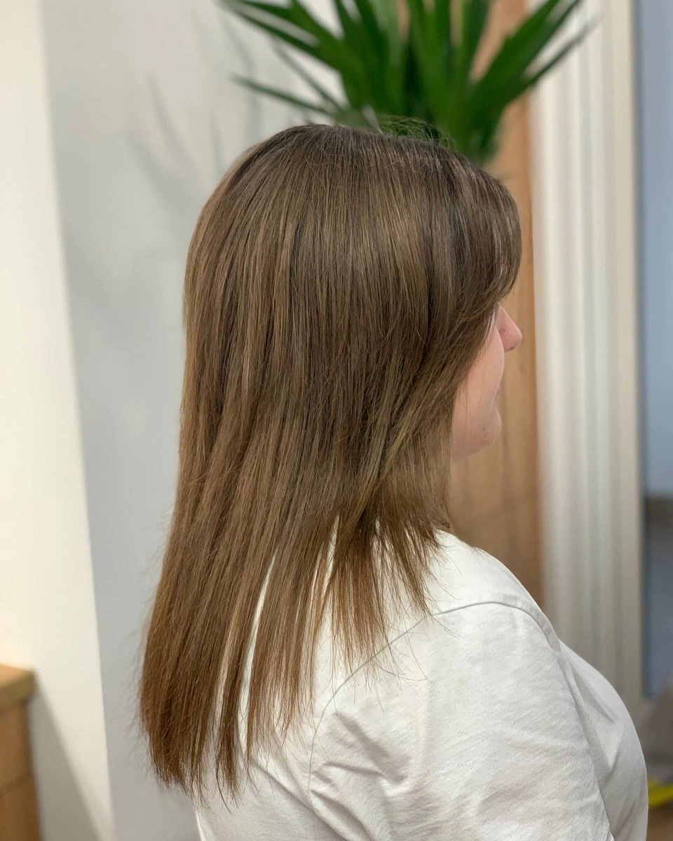 Longer straight brunette cut with face-framing front pieces
