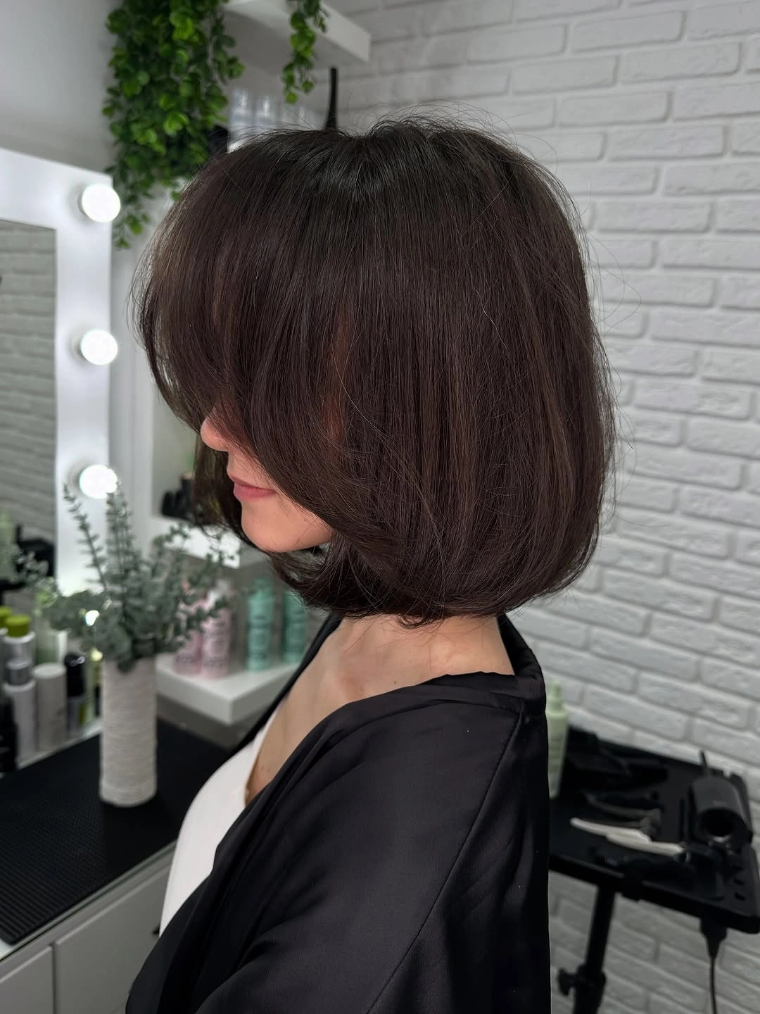 Dark brunette rounded bob with sweeping bangs and curved ends
