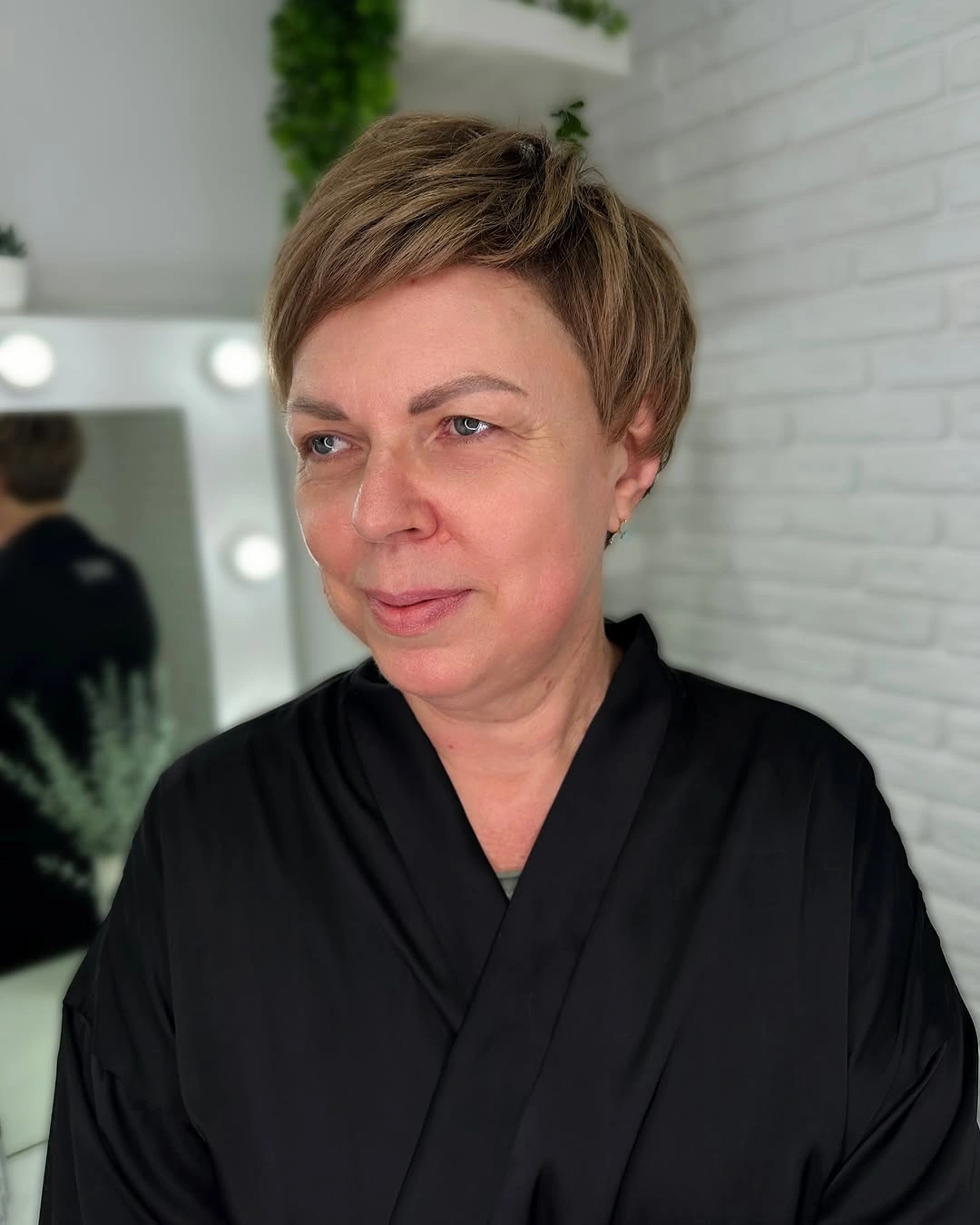 Short warm brunette pixie with side swept highlighted top