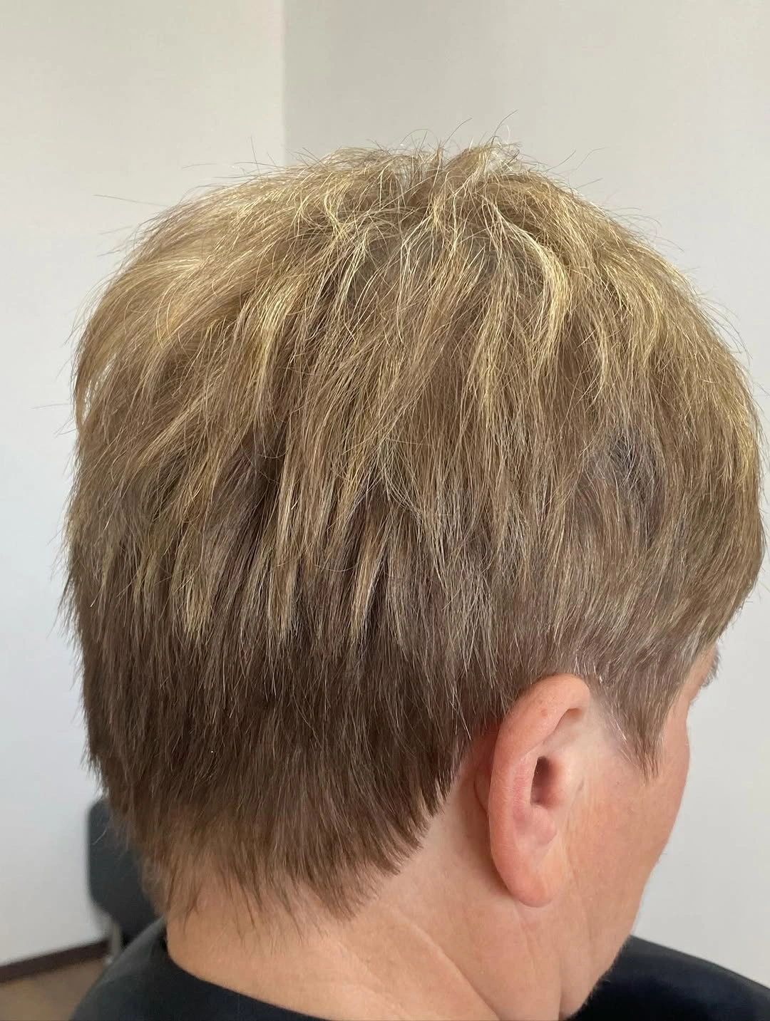Short ash-blonde brown pixie with feathered tapered nape