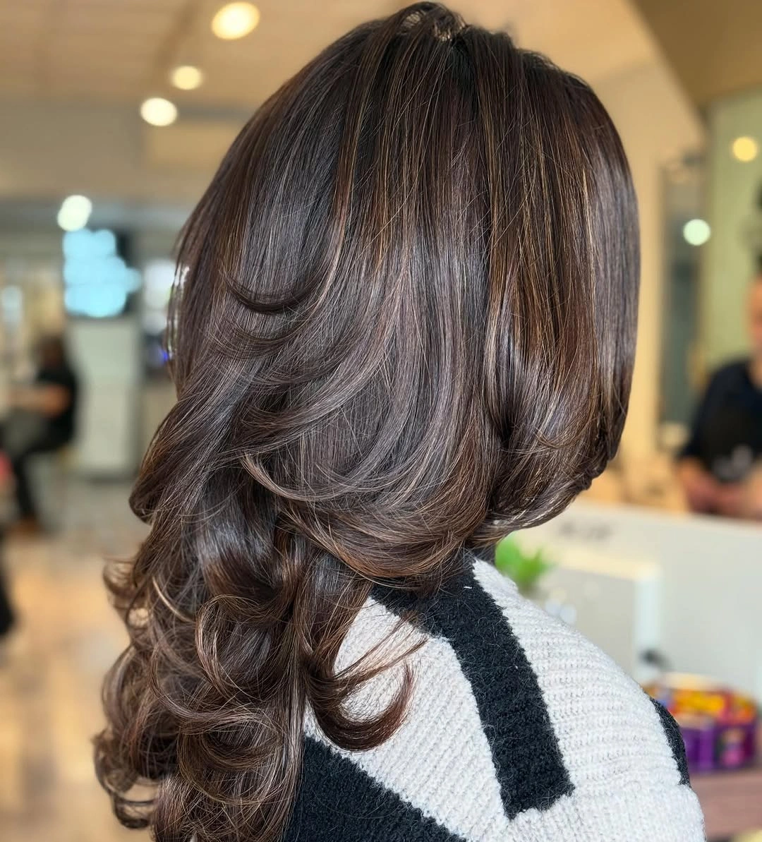 Dark brunette shoulder-length cut with feathered curved layered ends