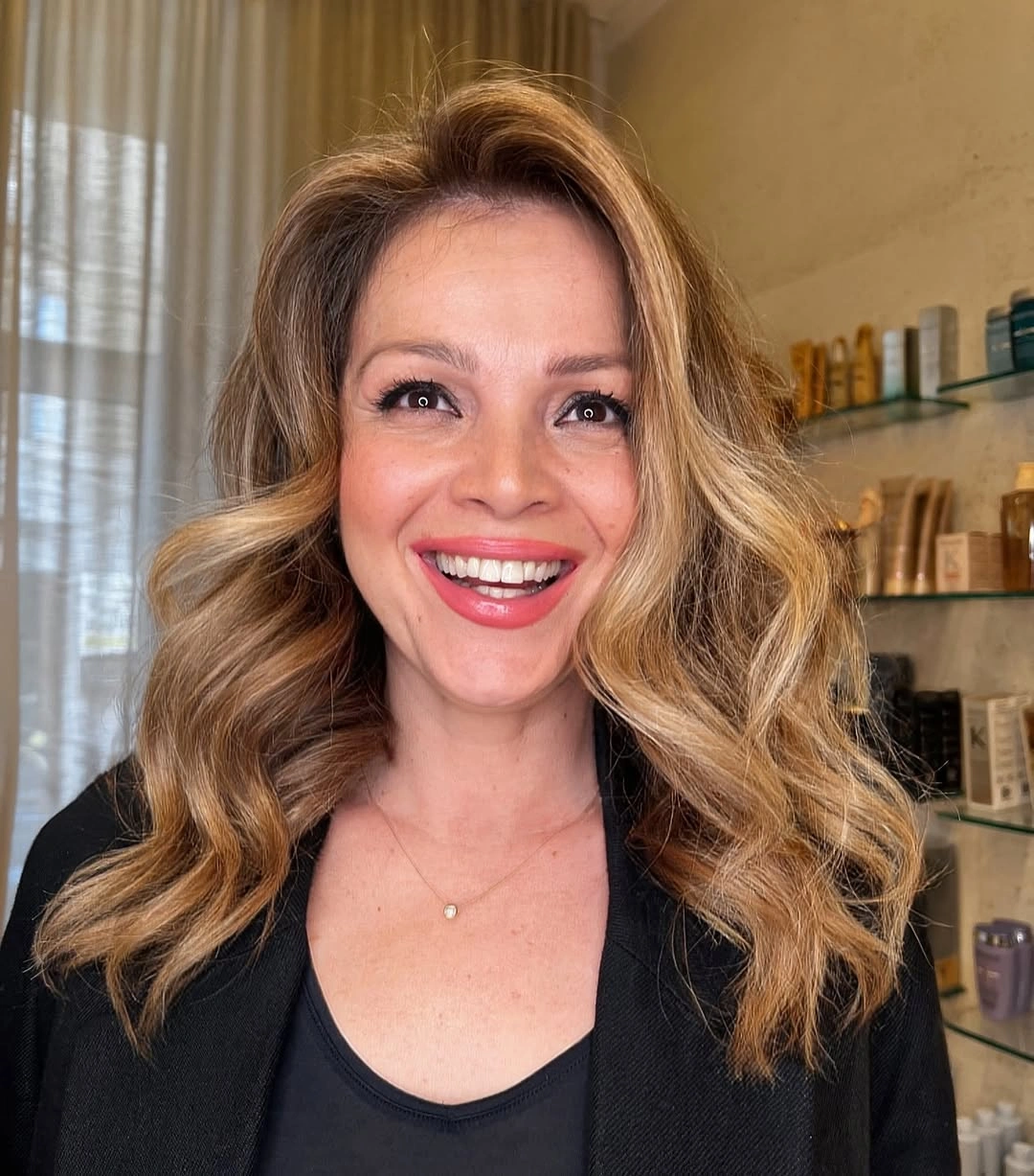 Warm copper blonde hair with large open shoulder-length waves