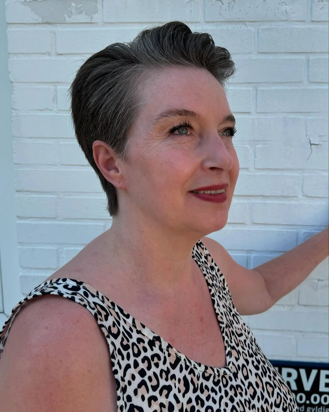 Short gray pixie with tapered sides and swept-back top
