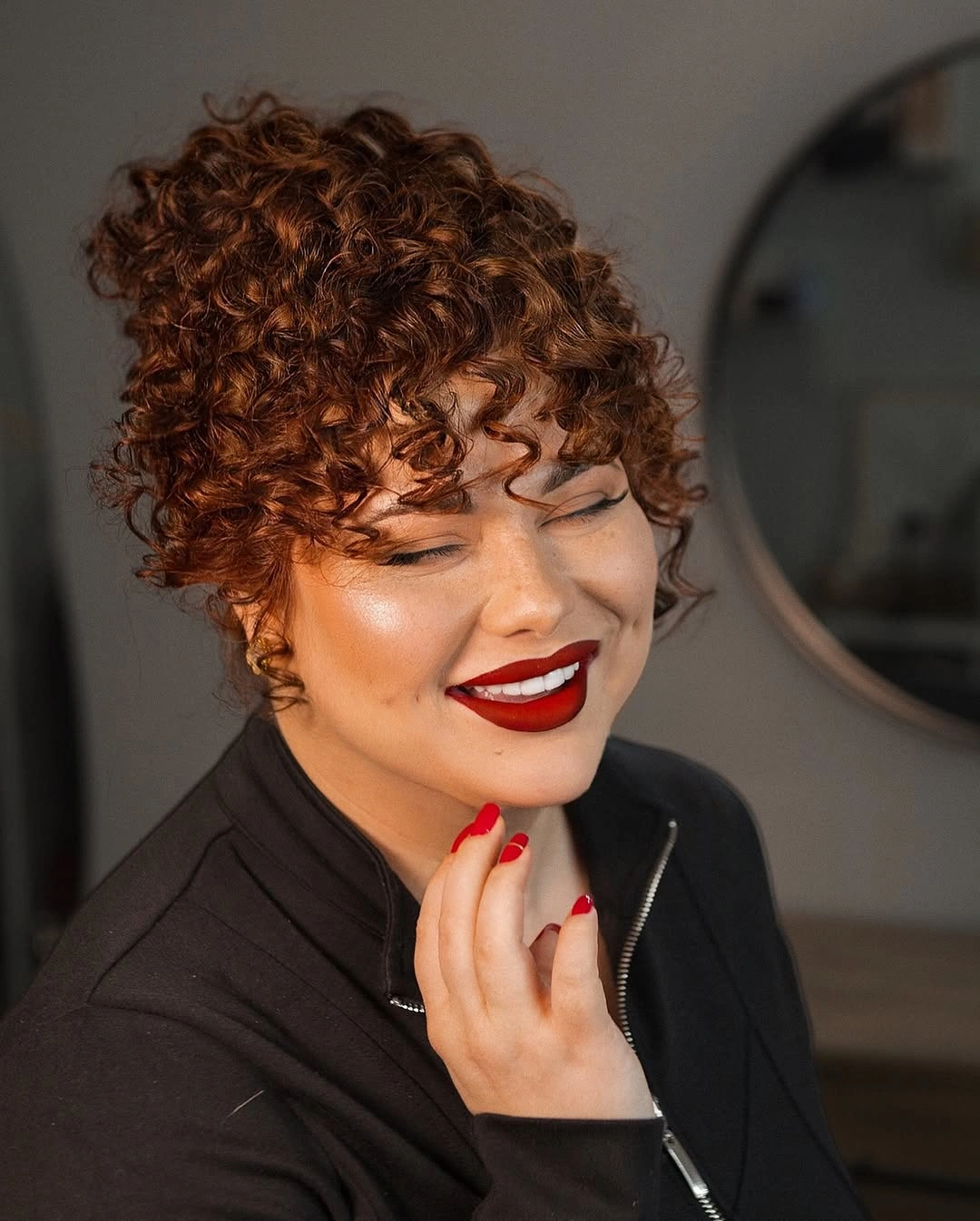 Copper-red short curly crop with rounded crown and curled fringe