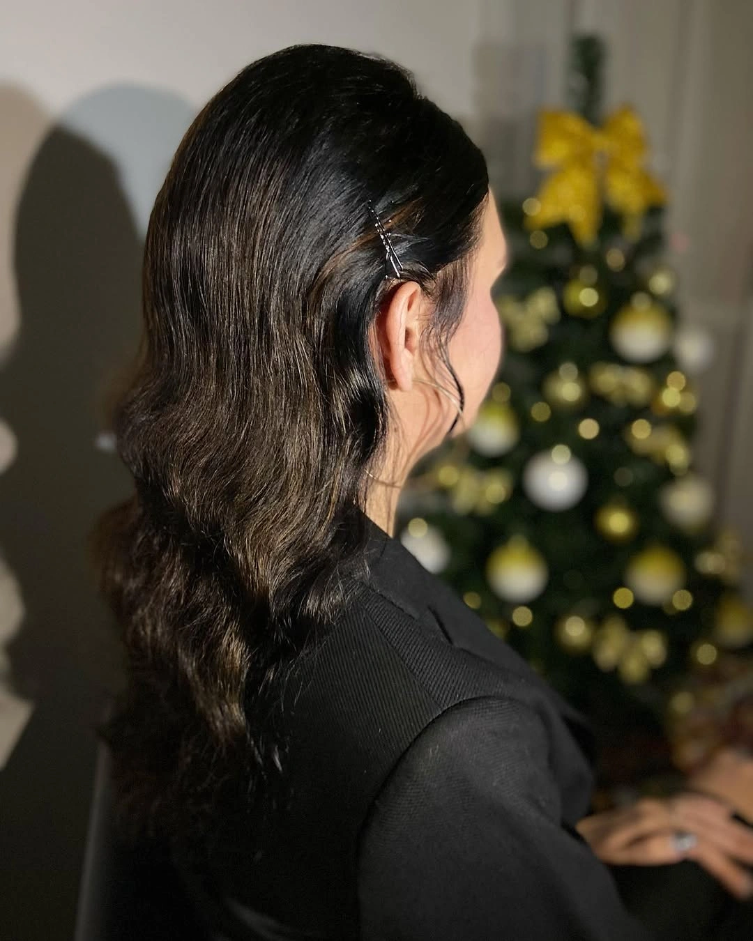 Long dark wavy hair with crossed pins behind one ear