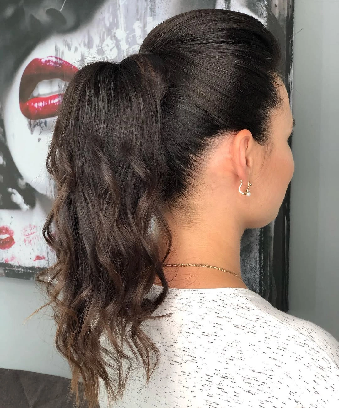 Dark high ponytail with smooth crown and long wavy tail