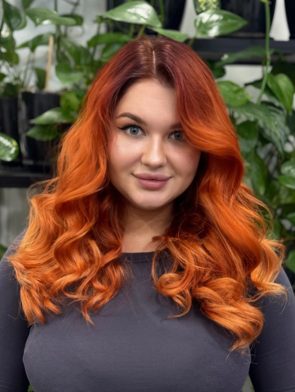 Copper-orange shoulder-length hair with center part and large curls