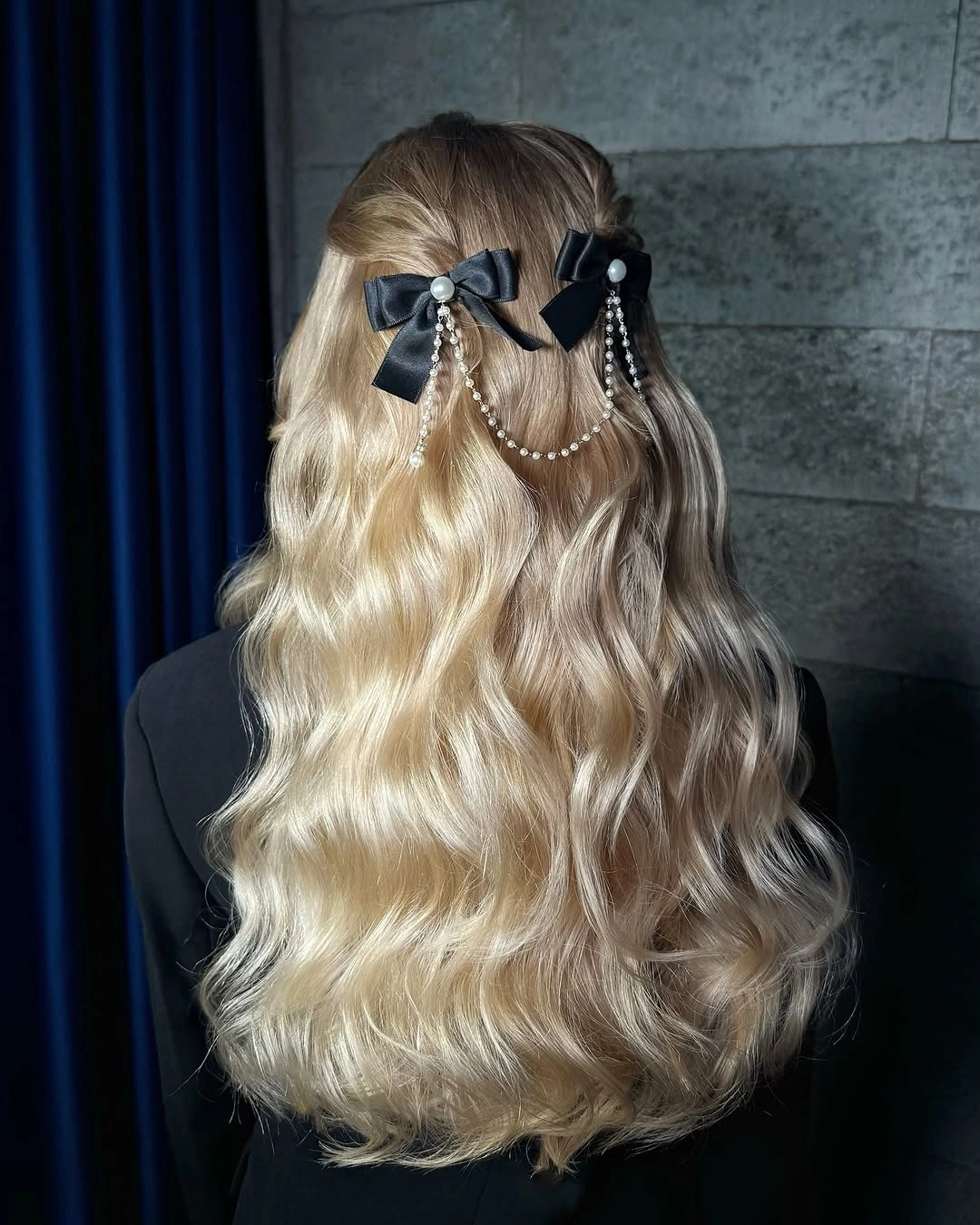 Long blonde waves with black bows and pearl-like draped strands