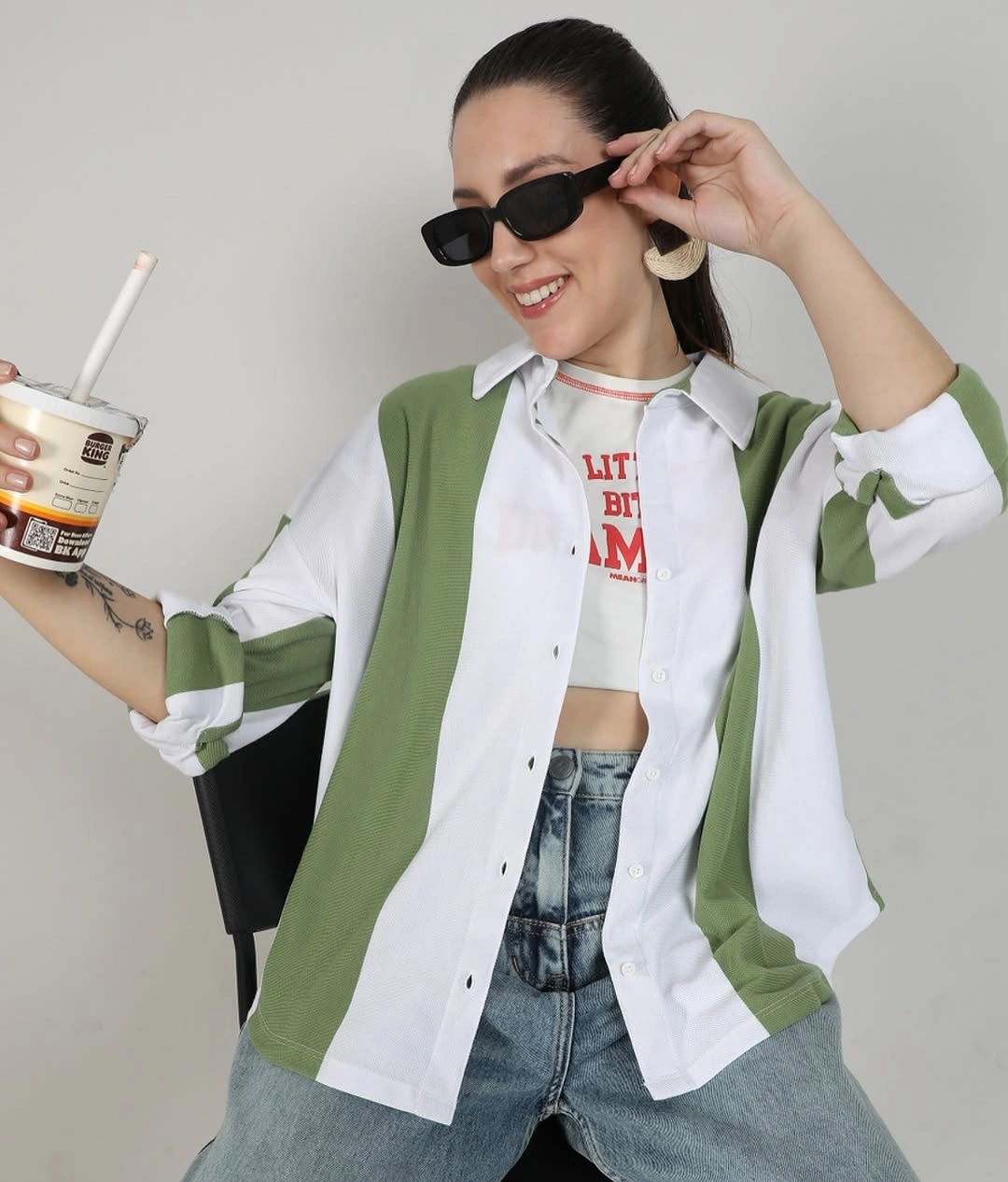 Woman wearing long olive padded vest over black fitted outfit