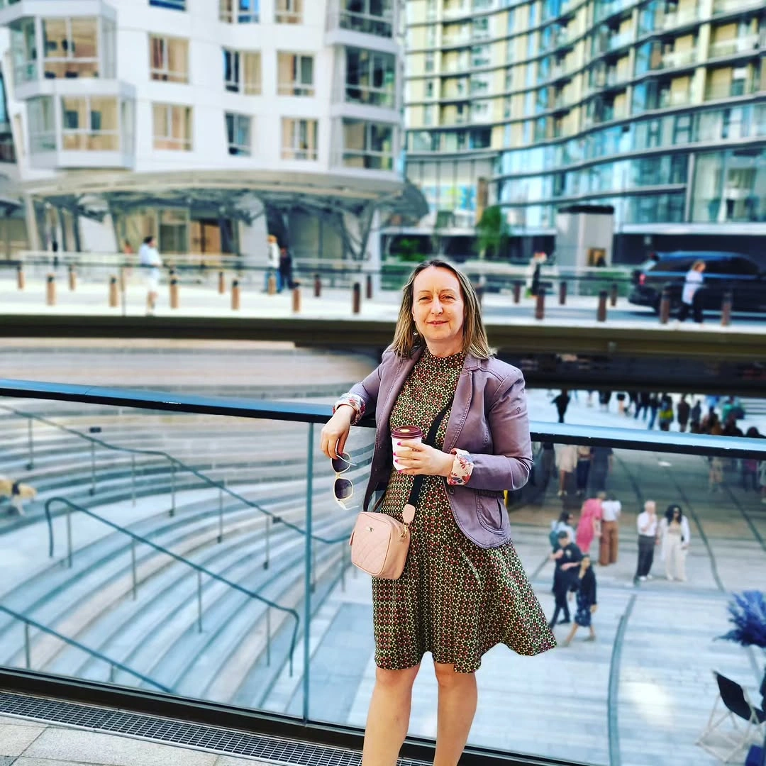 Lavender blazer over patterned dress with pale pink crossbody bag