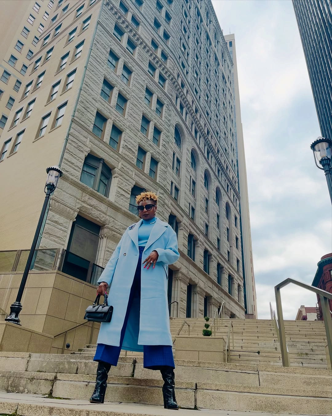 Light blue long coat with bright blue pants and black accessories