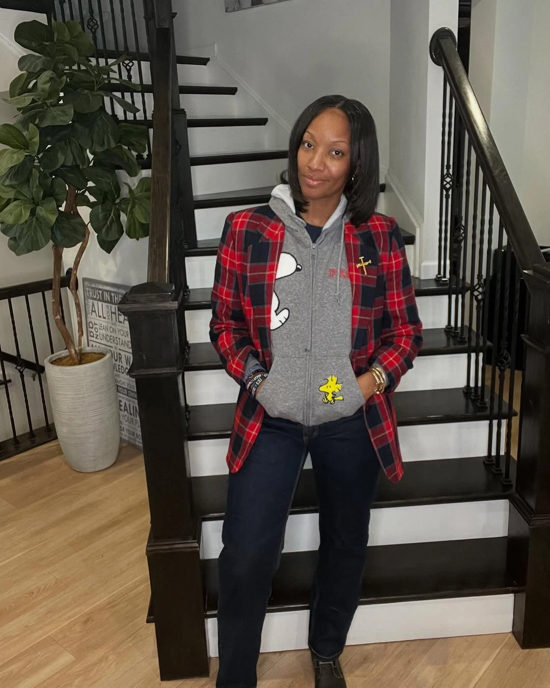Red plaid blazer over gray character hoodie and dark jeans