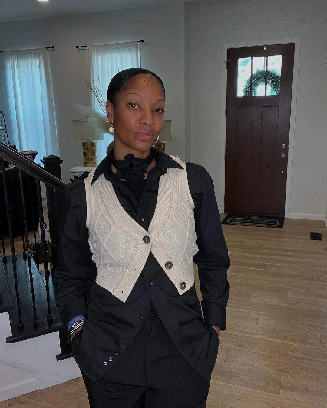 Cream cable vest over black shirt with dark neck detail