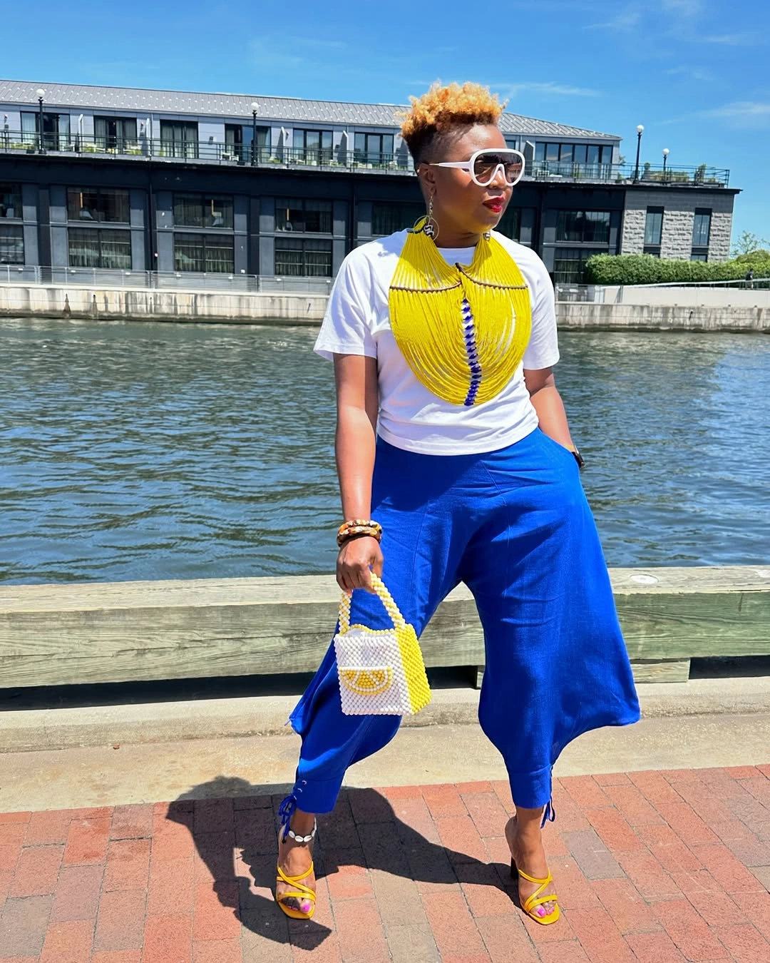 Woman in cobalt pants with yellow accessories and white tee