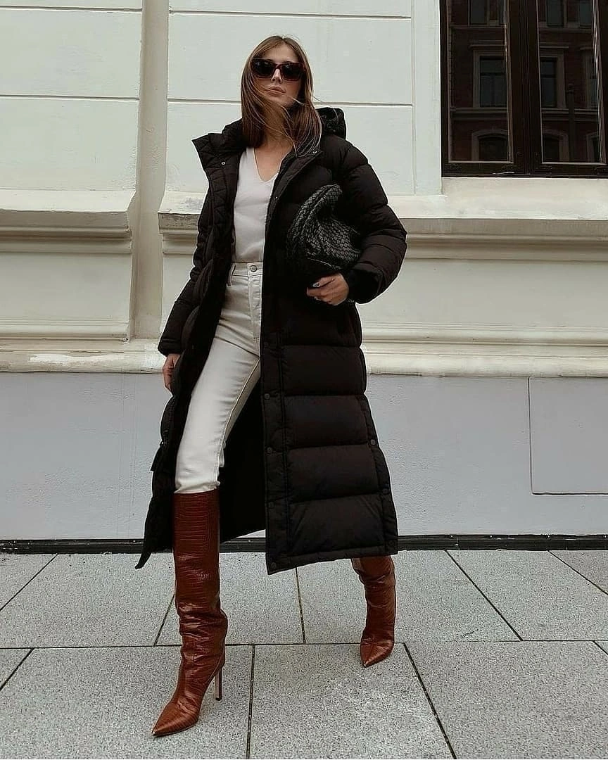 Long black puffer with white outfit and brown boots