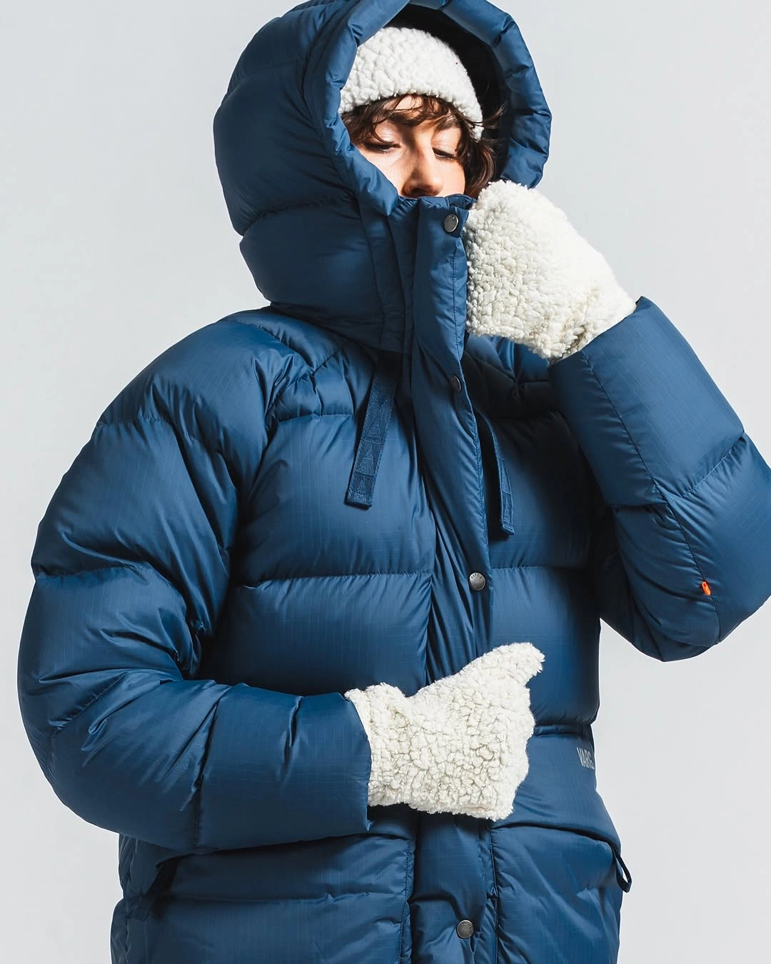 Navy hooded puffer with white headband and gloves