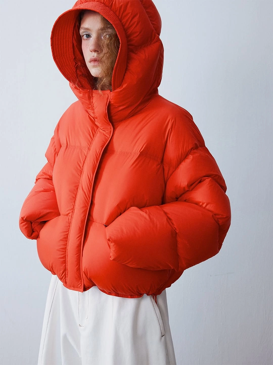 Red orange cropped puffer with large hood and white trousers