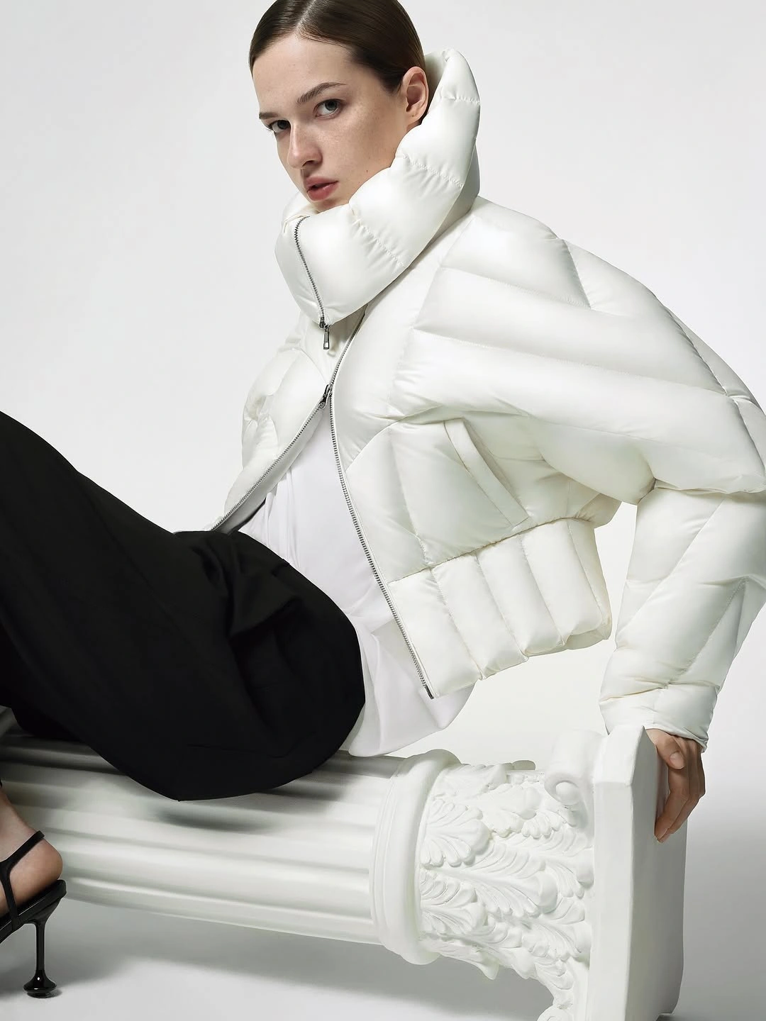 White cropped puffer with high collar and black trousers