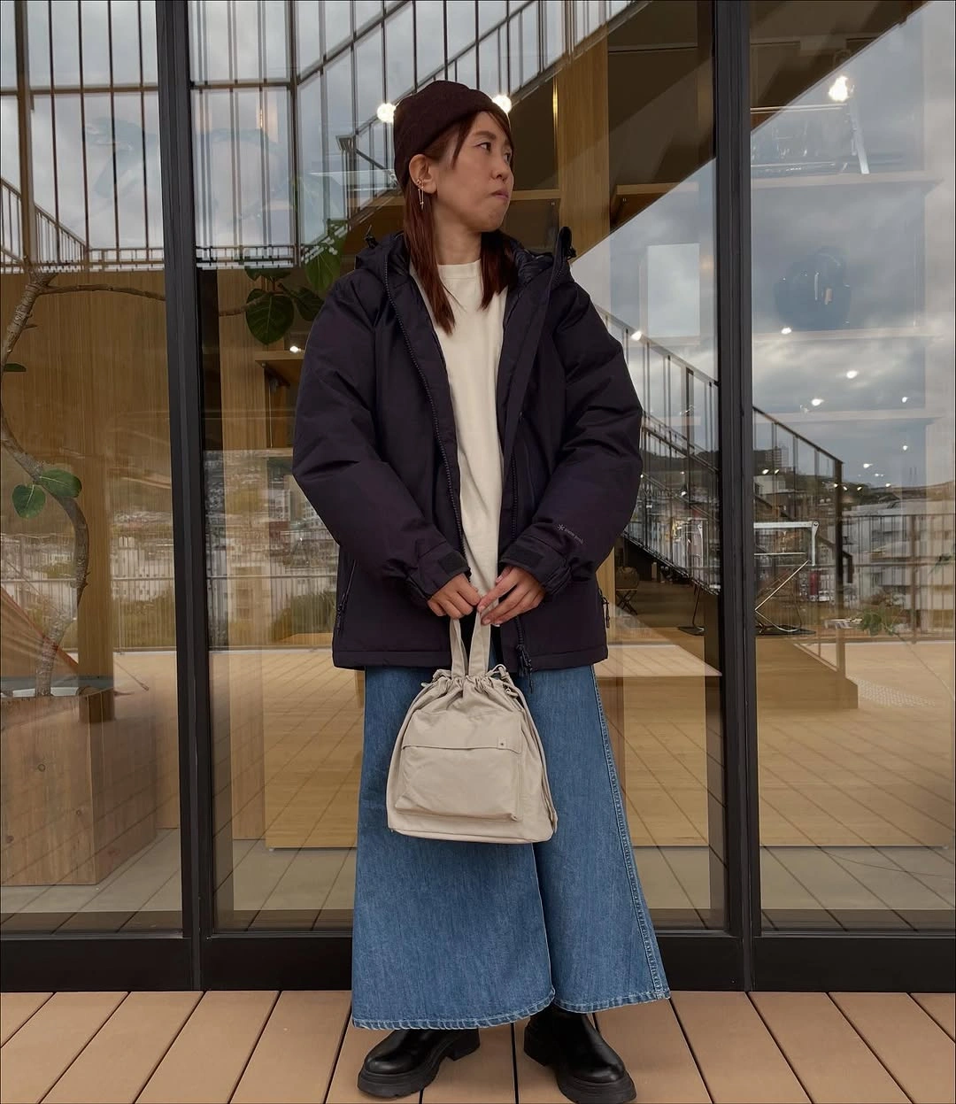 Dark navy puffer with cream sweater and wide denim bottom
