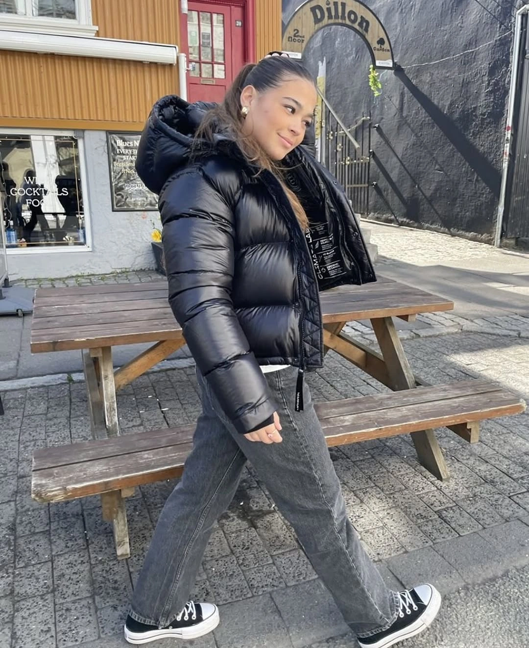 Shiny black puffer with gray jeans and high-top sneakers