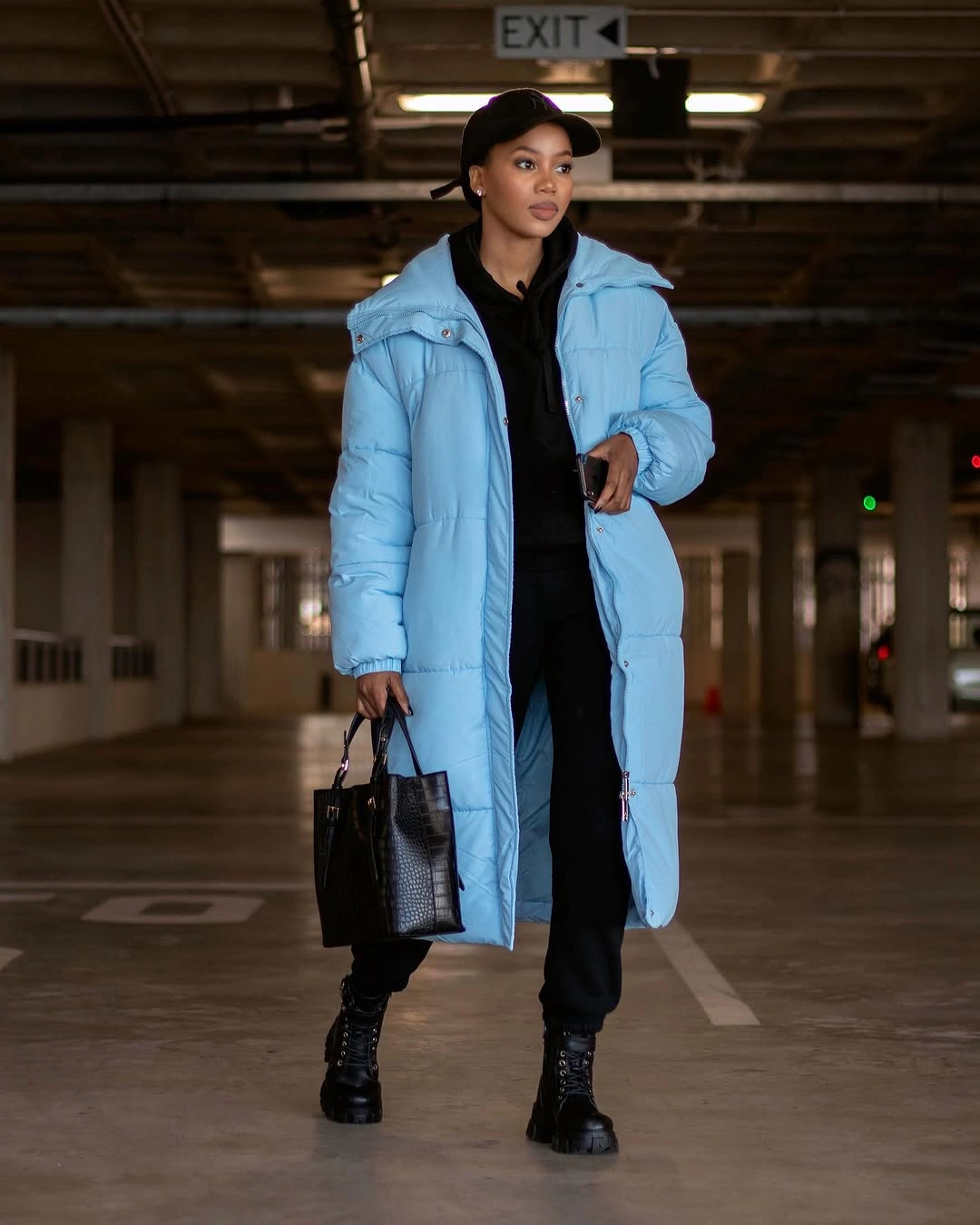 Bright blue long puffer with black layers and boots