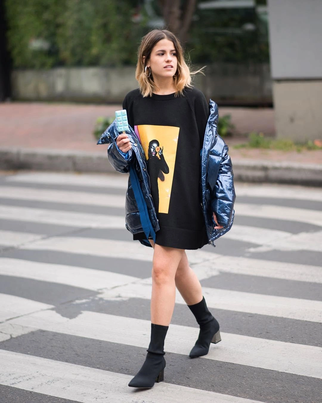 Metallic blue puffer over black graphic top and ankle boots