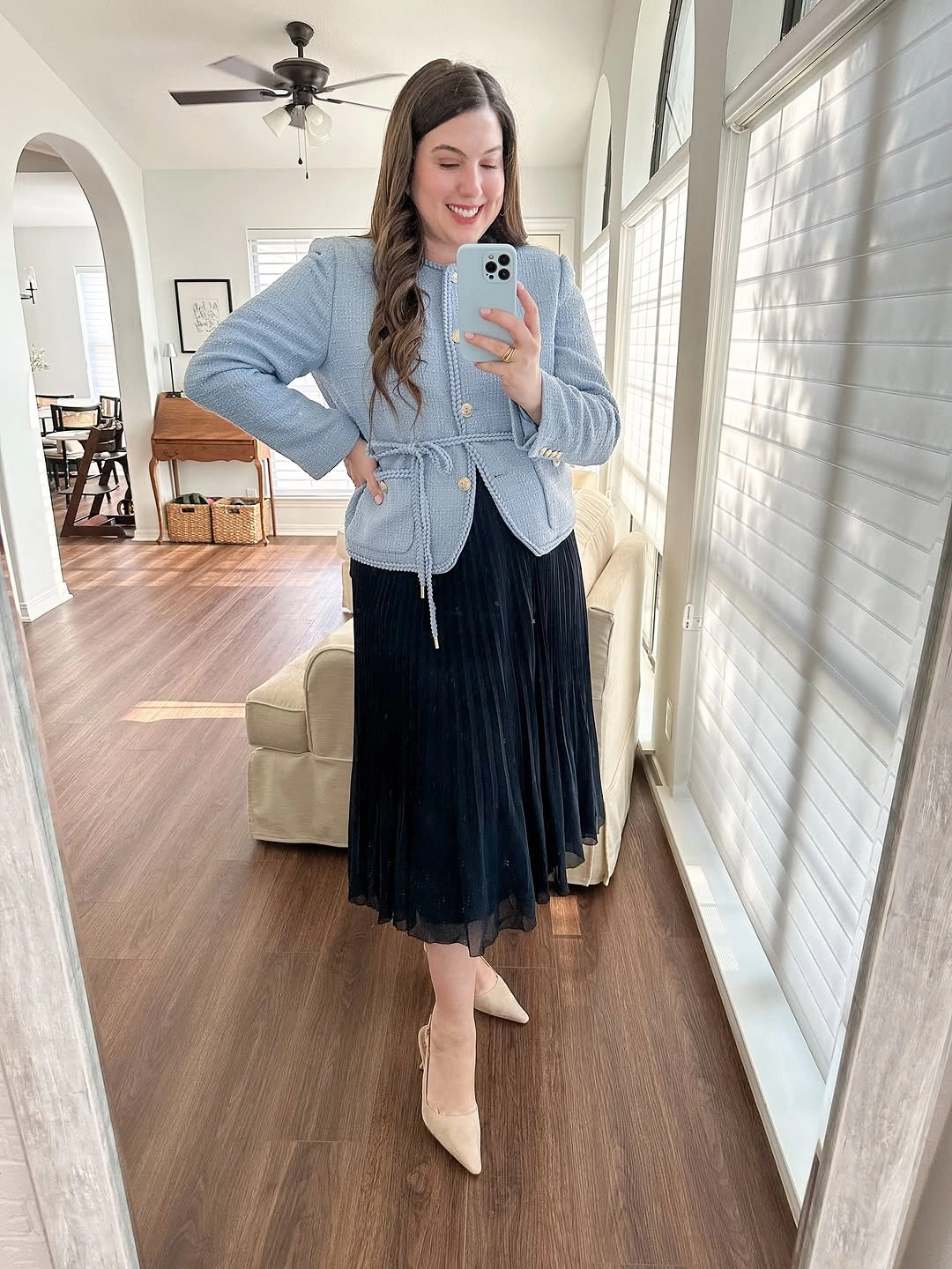 Pale blue waist-defined jacket with black pleated midi skirt