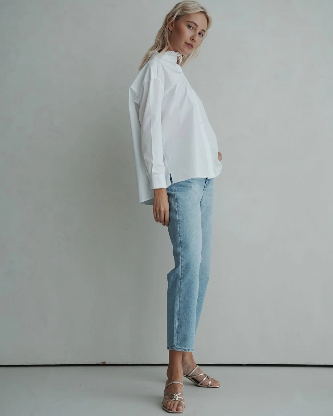 Oversized white button-up with cropped jeans and metallic strappy heels