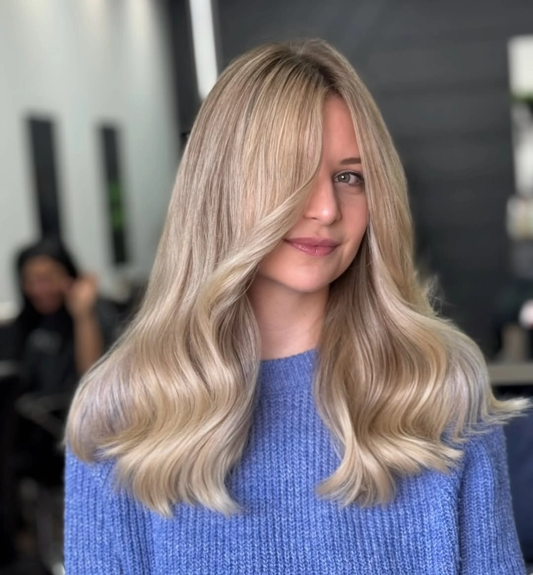 Creamy blonde waves with beige roots and pale face framing
