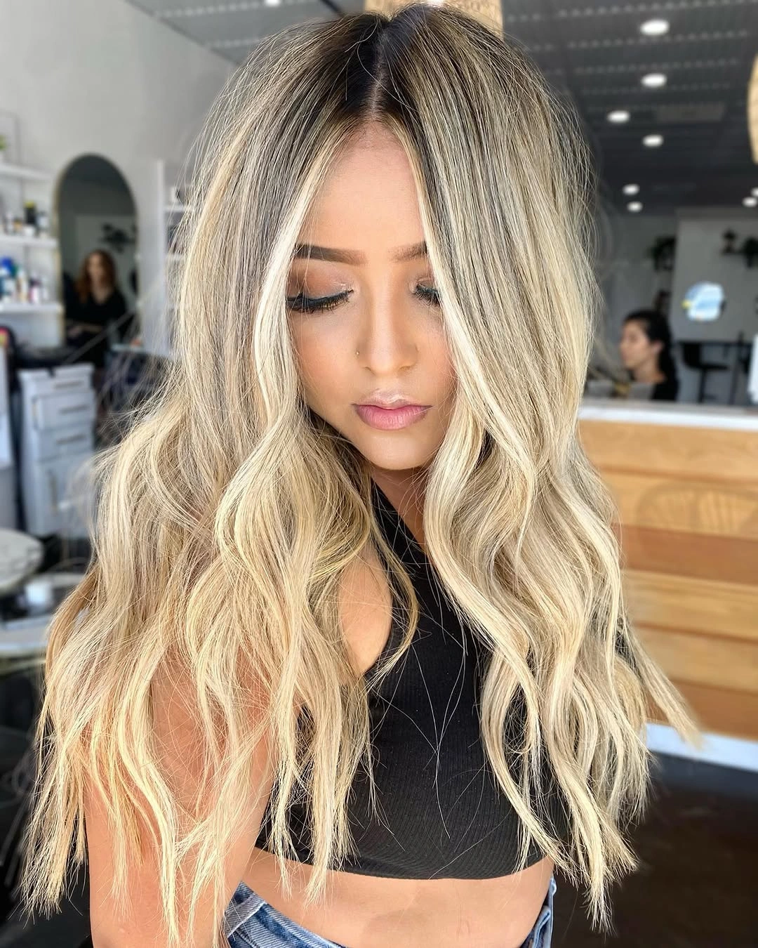 Long bright blonde waves with strong dark center roots