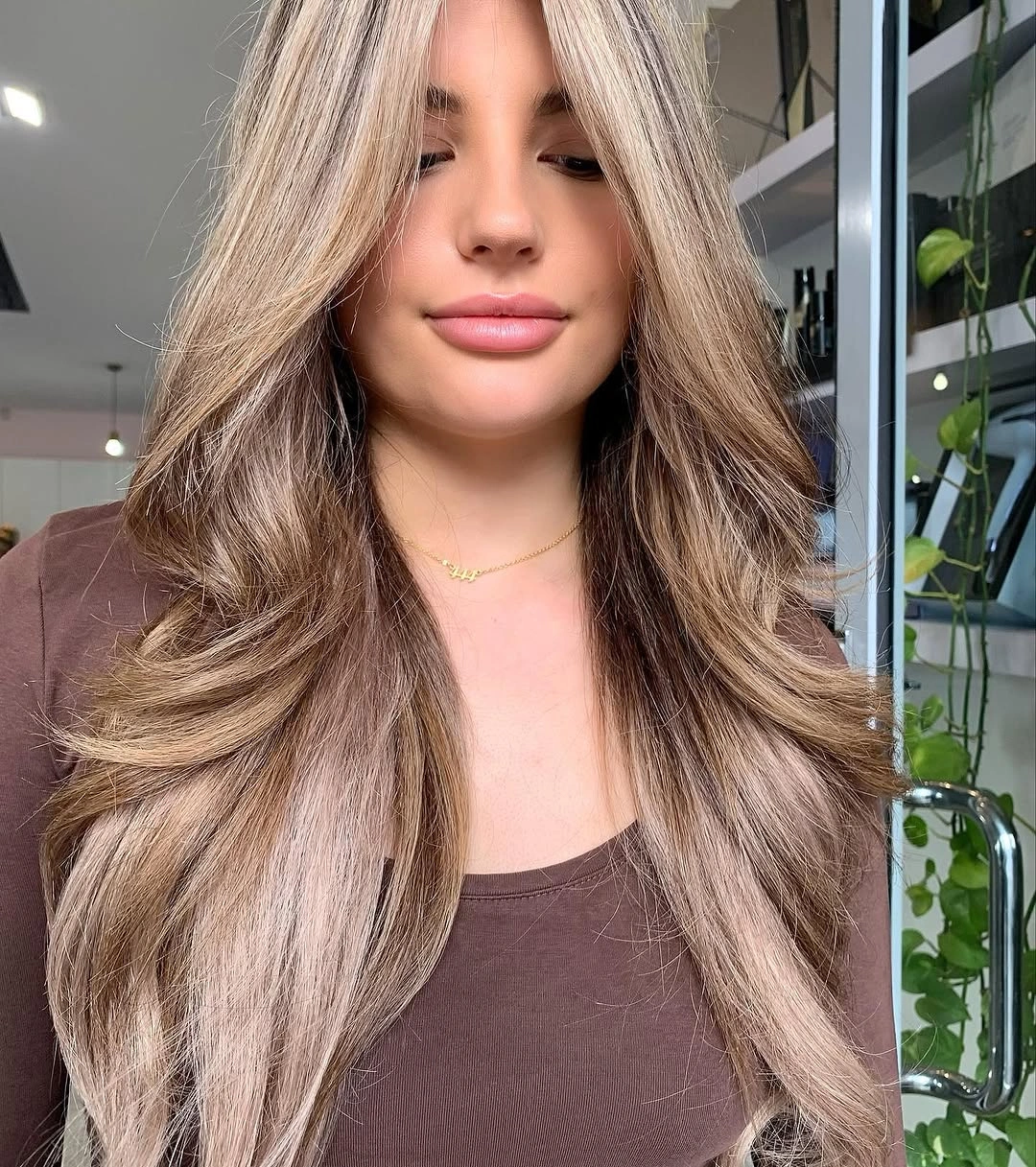 Long beige blonde layers with taupe root depth
