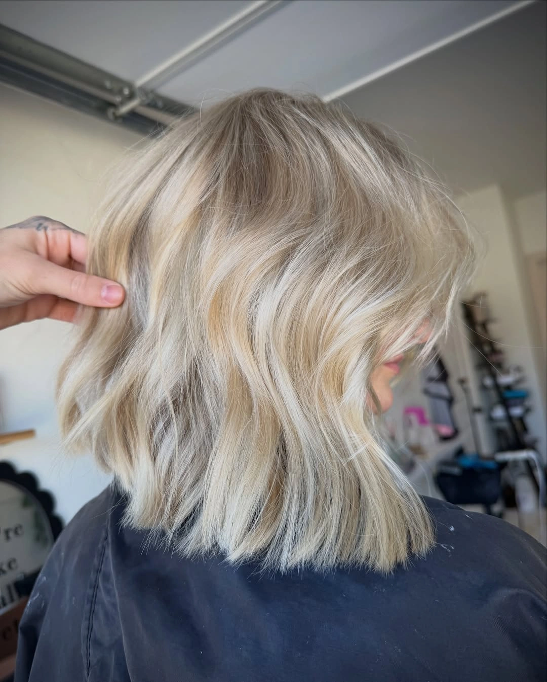 Short wavy blonde bob with creamy ribbons and shadowed roots