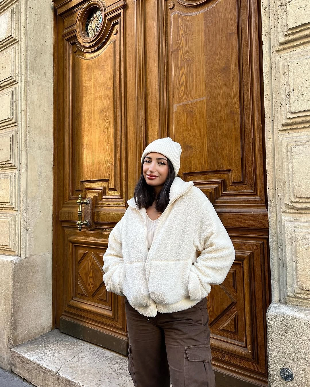ivory fleece jacket with brown cargo trousers and white beanie