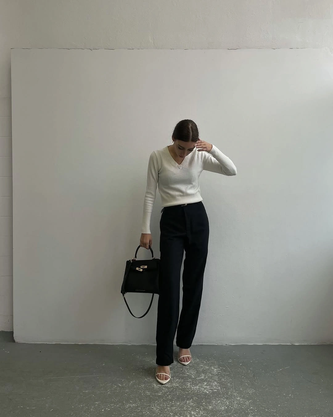 fitted white top with high-waist black trousers and structured black bag
