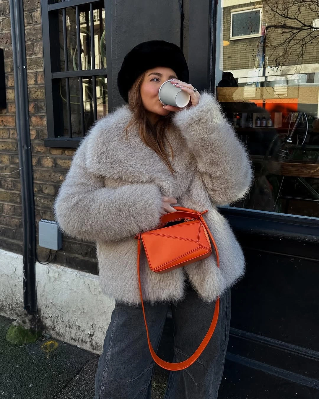 pale gray textured coat with gray trousers black beanie and orange crossbody
