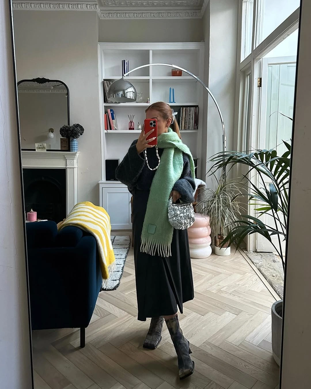 black long coat with gray scarf green accent and ankle boots