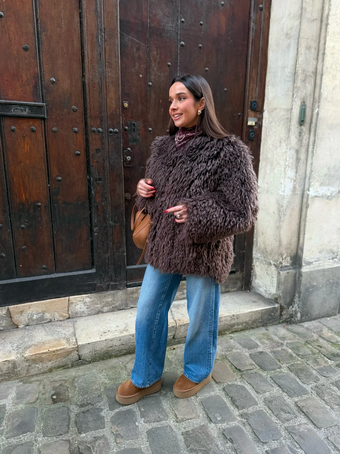 brown textured jacket with blue straight jeans and tan ankle boots