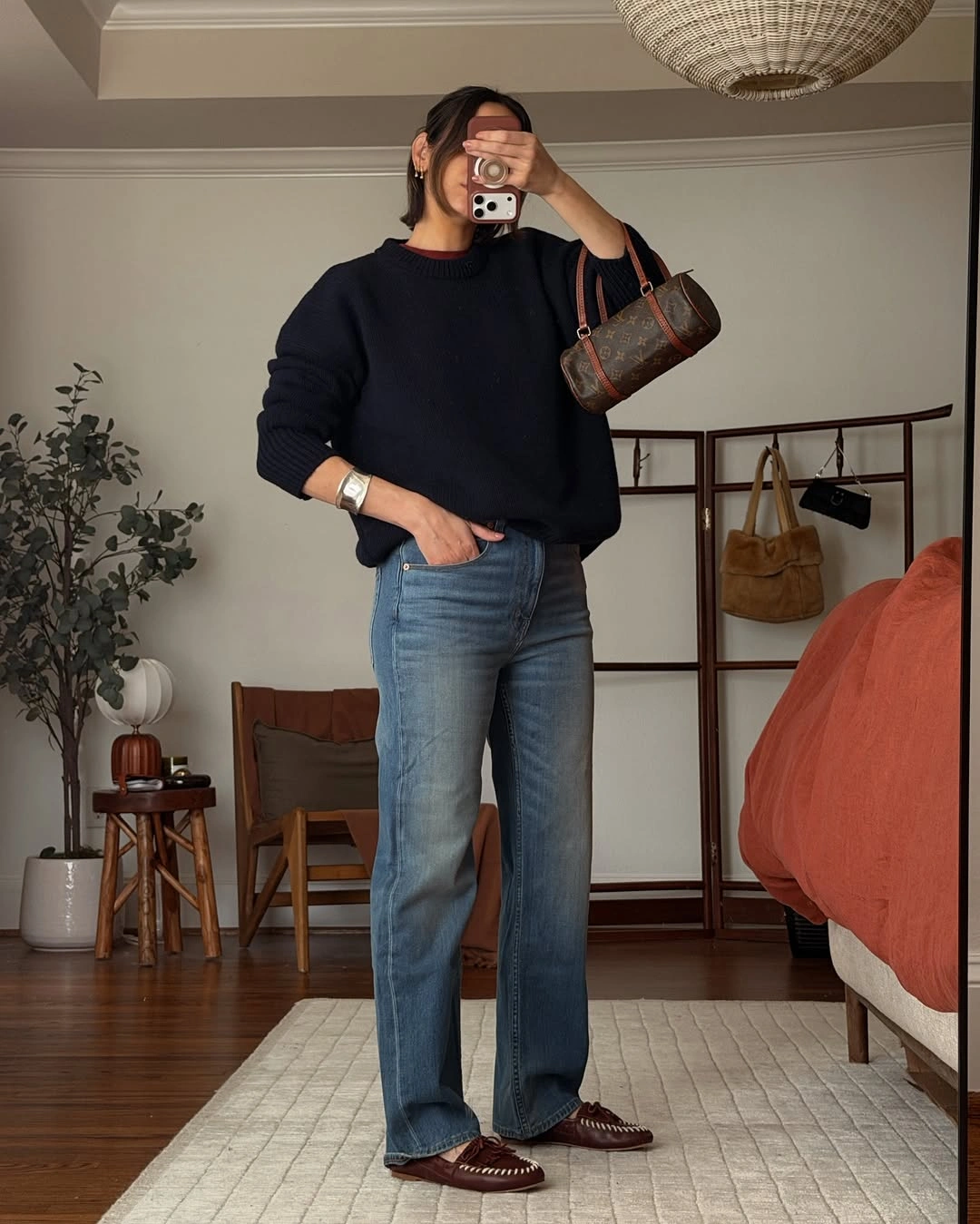 Navy sweater with straight jeans, burgundy shoes, and small bag