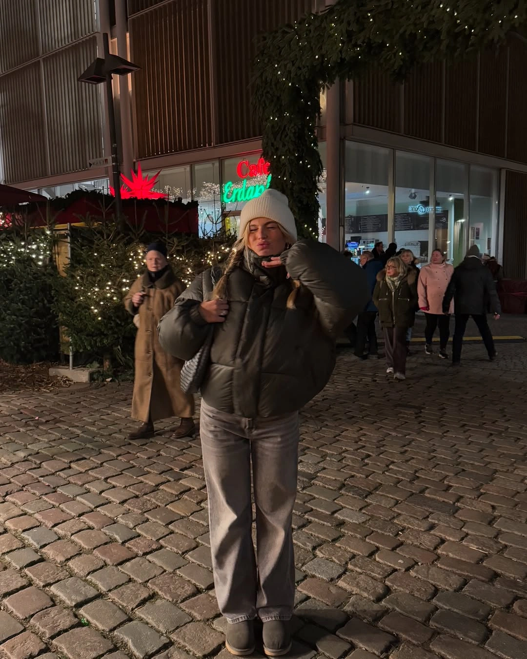 Dark puffer jacket with gray wide-leg jeans and white beanie