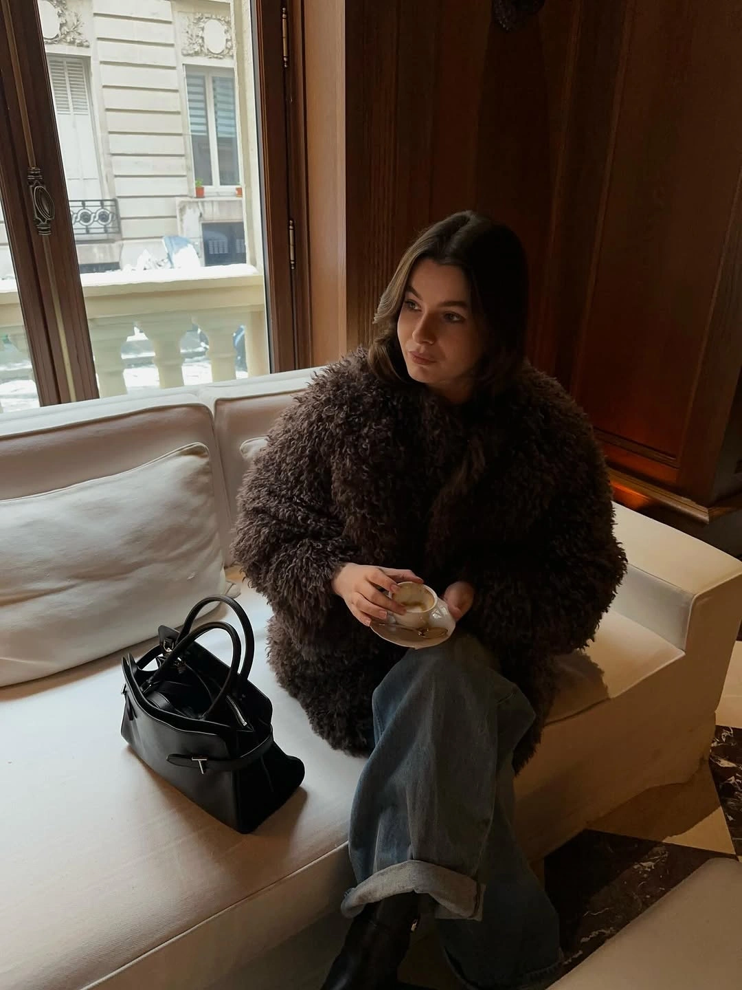 Dark brown textured-looking jacket with cuffed jeans and black bag