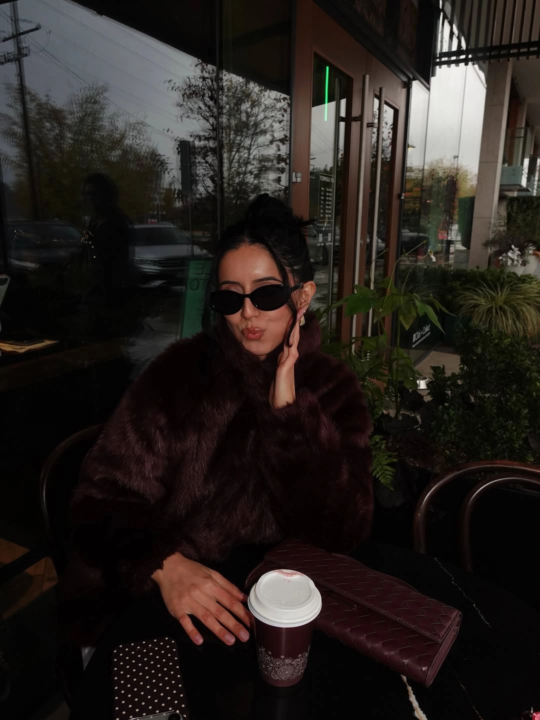 Deep burgundy fuzzy-looking top with quilted bag and dark outfit