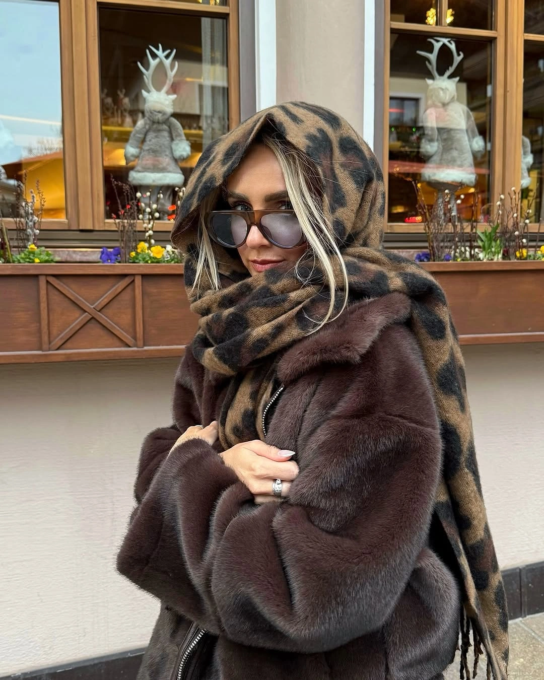 Brown textured-looking coat with animal-print scarf and sunglasses