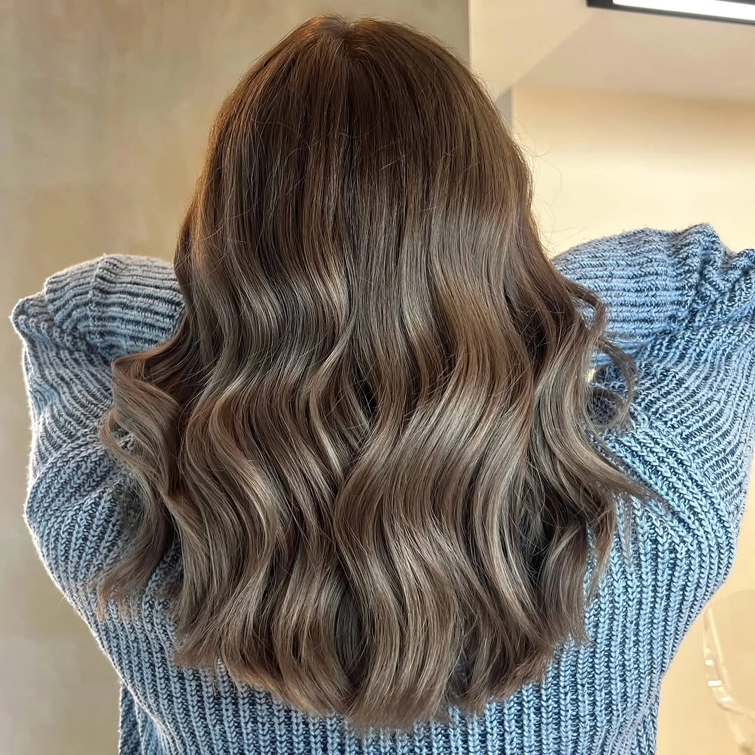 Long wavy brown hair with cool taupe-gray highlights