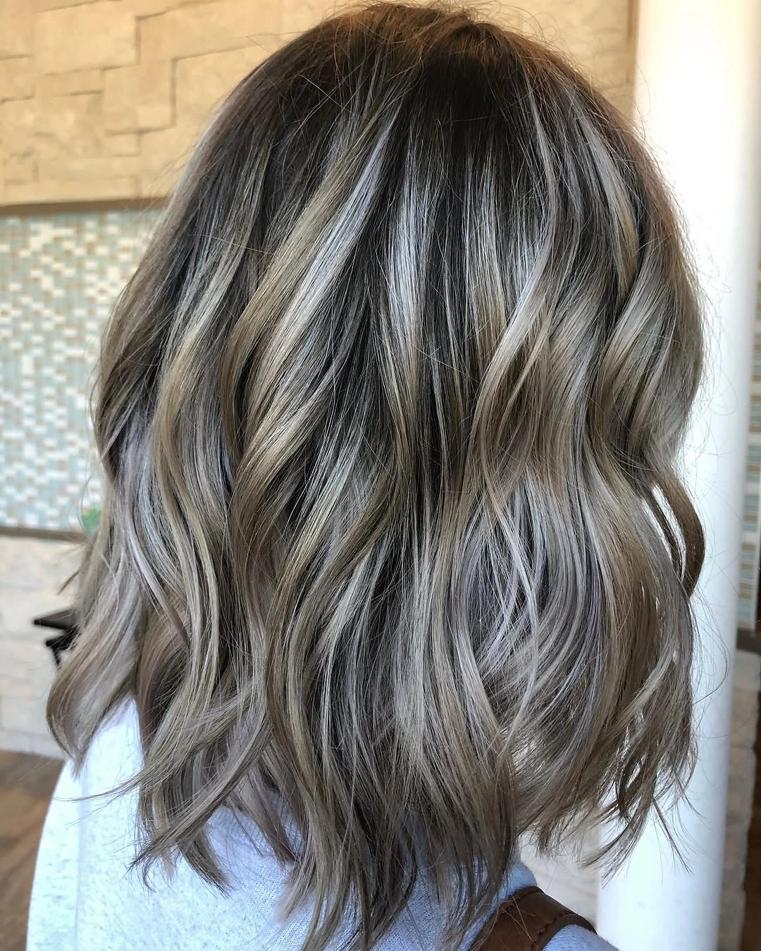 Shoulder-length dark ash brown hair with silver-gray highlights