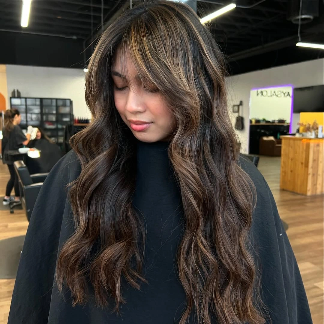 Long dark brown hair with caramel face-framing highlights