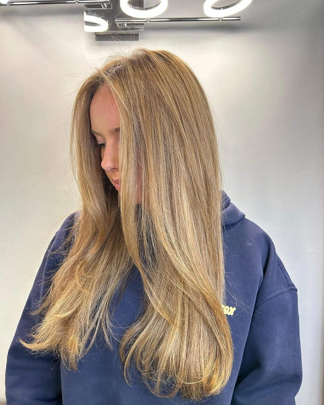 Long wavy honey beige blonde hair from side front view